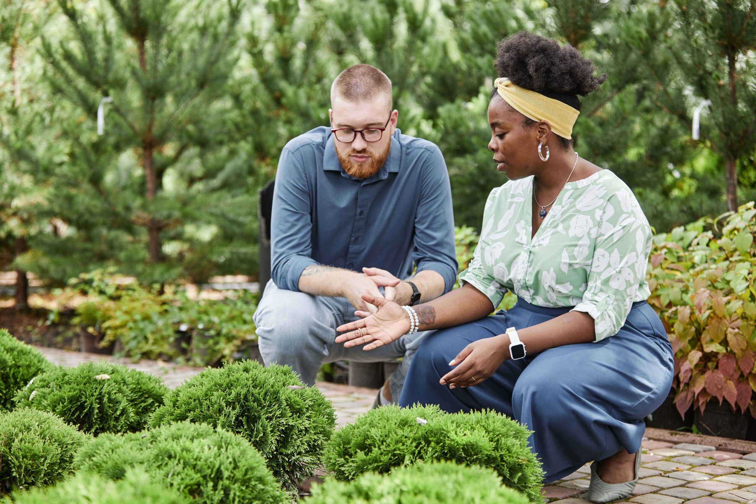 Male Client Talking to Black Female Landscape Designer Choosing Shrubs in Plant Nursery