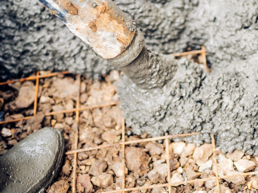 close up of construction workers using cement pump tube